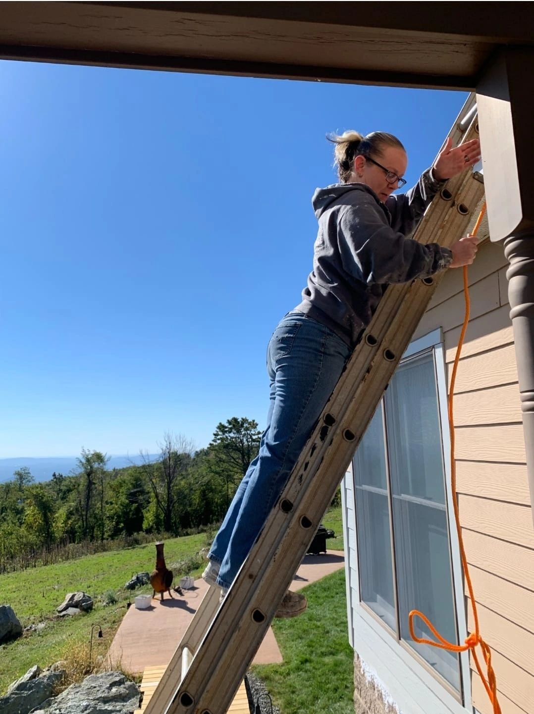 One of the women behind Finishing Touch Painting working from a ladder on an exterior project